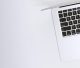 Free Aerial view of a sleek laptop keyboard on a clean, white surface, ideal for tech backgrounds. Stock Photo