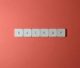Free Close-up of keyboard keys spelling 'BACKUP' placed on a coral-colored surface. Stock Photo